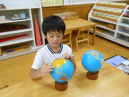 地球儀を学ぶ園児の写真