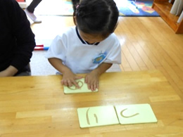 砂文字を学ぶ園児の写真
